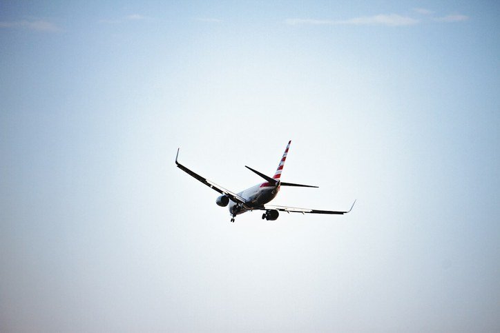 Commercial passenger aircraft flying towards Dubai for UAE Golden Visa and immigration services