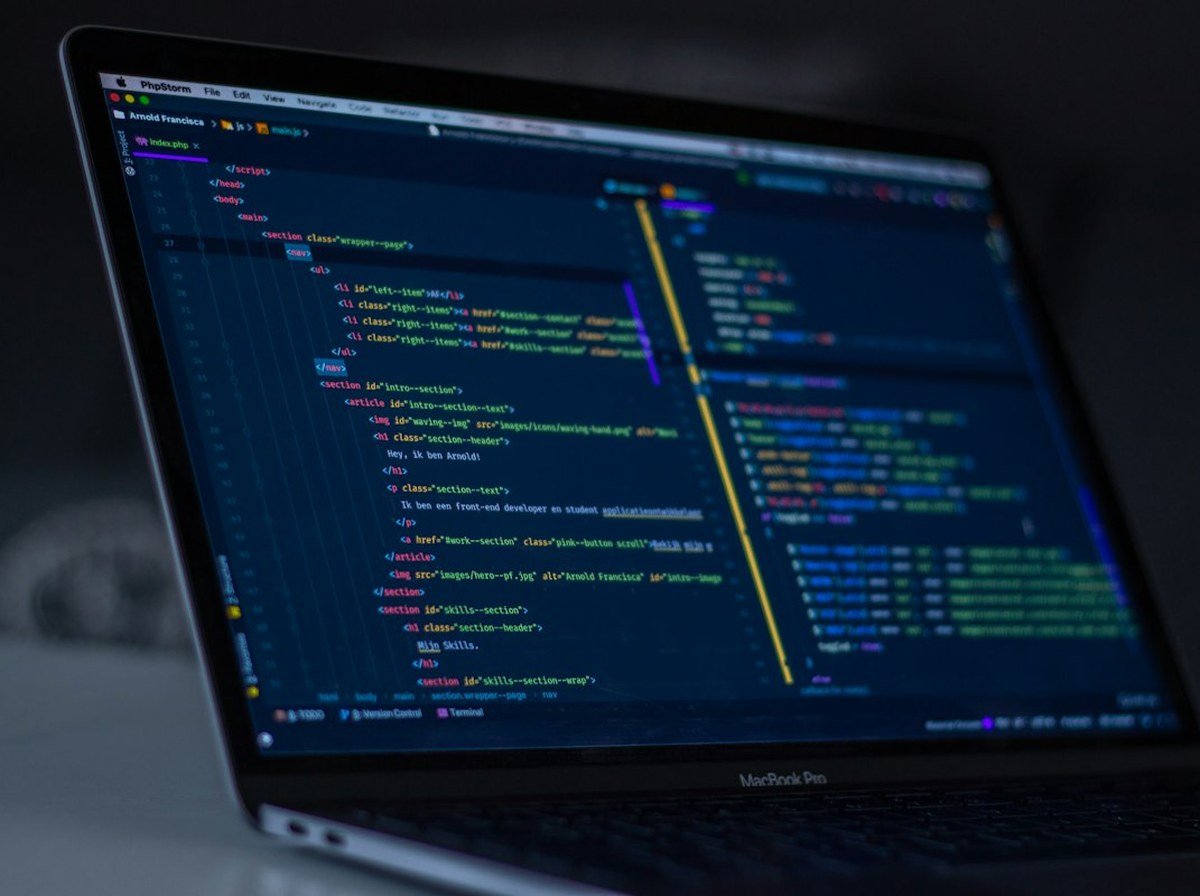 Modern laptop displaying clean web development code and digital solutions interface